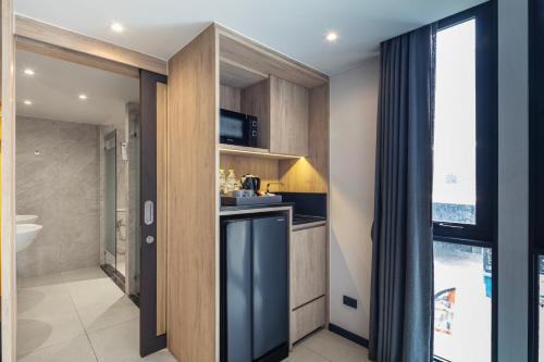 a kitchen with wooden cabinets and a counter top at Best Western Ratchada Hotel in Bangkok
