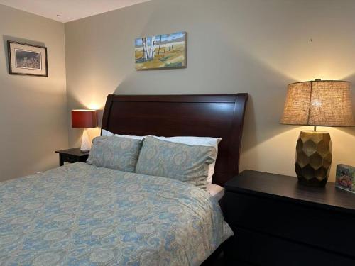 a bedroom with a bed and a nightstand with a lamp at UBC Two-Bedroom Suite - Steps from Beach, Park & Golf - Full Kitchen in Vancouver