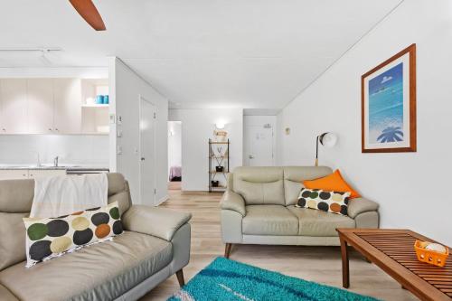 a living room with two couches and a table at Baden 59 - Rainbow Shores - Pool - Tennis Court - Walk to beach in Rainbow Beach