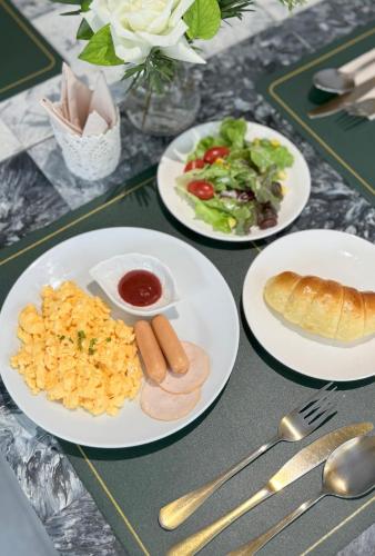 a table with three plates of food on it at Metz Pratunam in Bangkok