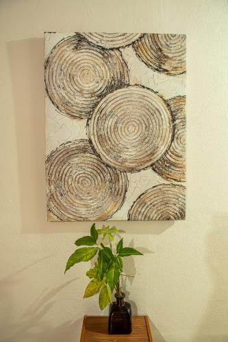 a painting on a wall with a plant on a table at The Backside House -women only- in Tamarindo