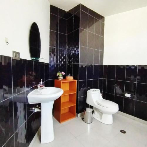ein Badezimmer mit einem weißen Waschbecken und einer Toilette in der Unterkunft Apart Madrid Yanahuara in Arequipa