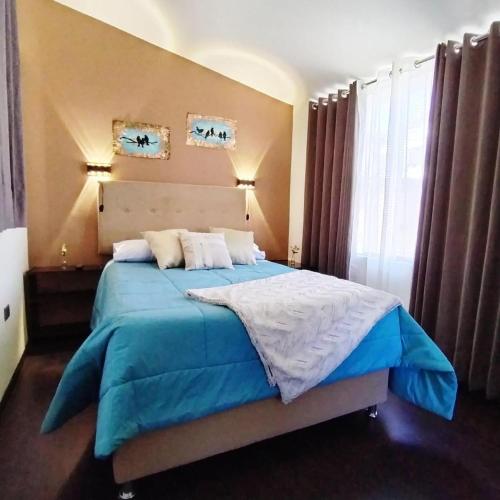ein Schlafzimmer mit einem großen Bett mit einer blauen Decke in der Unterkunft Apart Madrid Yanahuara in Arequipa