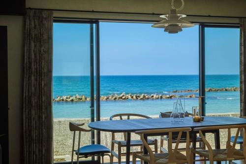una mesa con sillas y vistas al océano en West Shore Plus, en Awaji