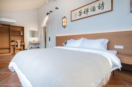 a bedroom with a large white bed in a room at The Lu Village Retreat in Guilin