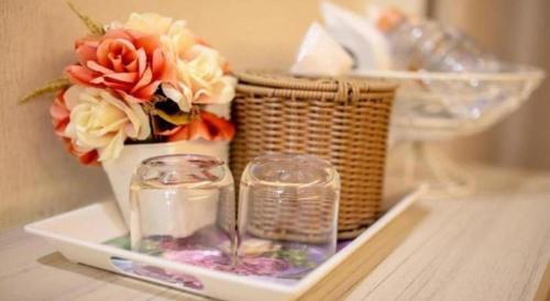a tray with a candle and flowers and a basket at Klang Muang @ Nongkhai Hotel in Nong Khai