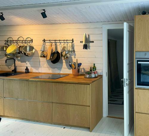 a kitchen with a counter with pots and pans at Holiday Home Near Tisvilde Forest And Rhubarb Farm in Vejby Strand