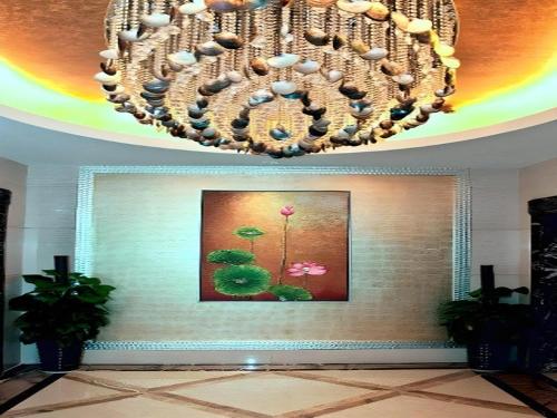 a chandelier in a room with a picture of flowers at Fuzhou Xin Zi Yang Hotel in Fuzhou