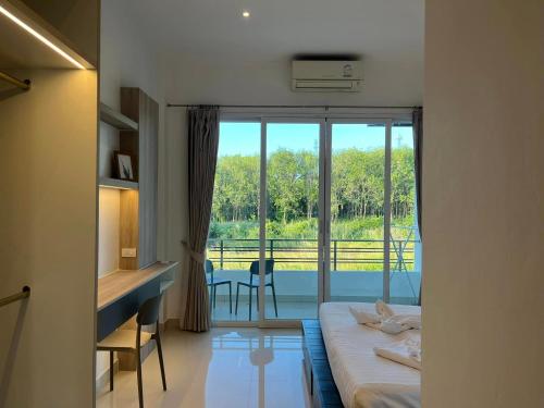a room with a bed and a desk and a window at Lanta Sport Resort in Ko Lanta