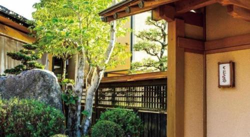 a building with a sign on the side of it at Nanaironoyu Hotel in Takeo