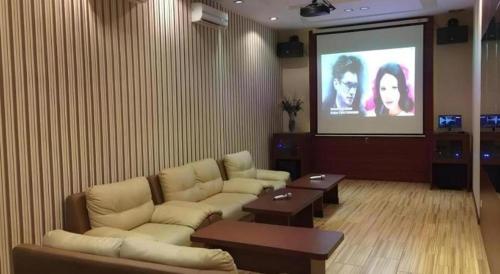 a living room with a couch and a projection screen at Mega Permata Hotel in Padangsidimpuan