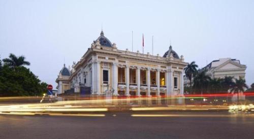a white building with lights in front of it at Hoang Hung Hotel in Hanoi