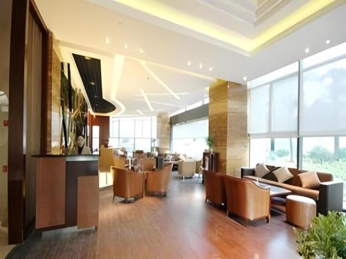 a lobby with couches and chairs in a building at Jinhua World Trade Hotel in Jinhua