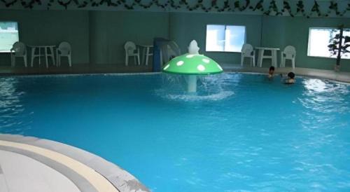 a swimming pool with a green object in the water at Jincheng Pacific Hotel in Jincheng