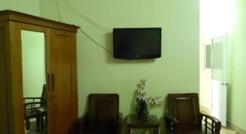 a living room with a table and a tv on the wall at Hoang Hung Hotel in Hanoi