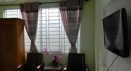 a living room with two chairs and a window at Hoang Hung Hotel in Hanoi