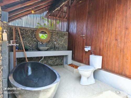 a bathroom with a large tub and a toilet at Golo Pada Villa Labuan Bajo by ABM in Nggorang