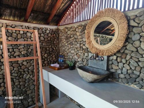 a bathroom with a stone sink and a mirror at Golo Pada Villa Labuan Bajo by ABM in Nggorang
