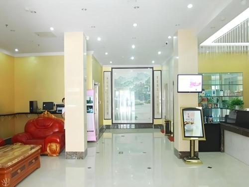 a lobby with a red couch and a large window at Kunlun Leju Business Hotel Kaifeng Gulou in Kaifeng