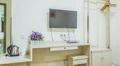 a desk with a television on top of it at Kunlun Leju Business Hotel Kaifeng Gulou in Kaifeng