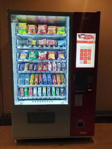 a refrigerator filled with lots of drinks and soda at V51 Hotel in Nakhon Ratchasima
