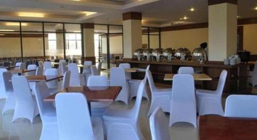 a room full of white chairs and tables and tables and tablesearcher at Hotel Mekkah Banda Aceh in Banda Aceh