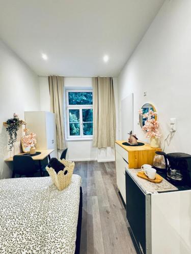 a room with a bed and a desk and a kitchen at Stylish & Comfy 1BR Apartment Very Central in Klosterneuburg