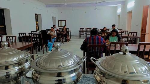 ジャイサルメールにあるSerendipity Desert Dunes Luxury Resort By Royal Empireのレストランのテーブルに座っている人々のグループ