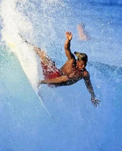 a man riding a wave on a surfboard in the water at Retro Star-Wagon, Ocean View Dolby Sound Studio in Oceanside