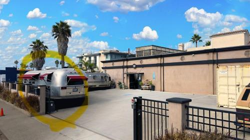 a parking lot with two rvs parked next to a building at Retro Star-Wagon, Ocean View Dolby Sound Studio in Oceanside