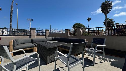 a patio with a table and chairs and a couch at Retro Star-Wagon, Ocean View Dolby Sound Studio in Oceanside