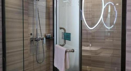a bathroom with a shower and a glass door at Xana Hotelle Xi'an GONG IP South Gate of Zhonglou in Xi'an