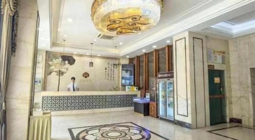 a lobby with a large chandelier in a building at Li An Hotel Shantou Xiashan Central Bus Station Branch in Shantou