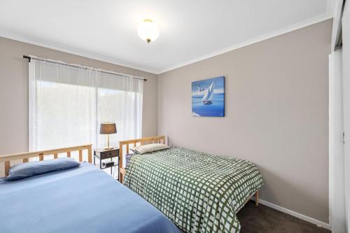 a bedroom with two beds and a window at The Pawfect Beach House in Cowes