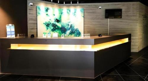 a counter in a room with a painting on the wall at Jinjiang Inn Select Tianjin Xiaobailou Metro Station in Tianjin