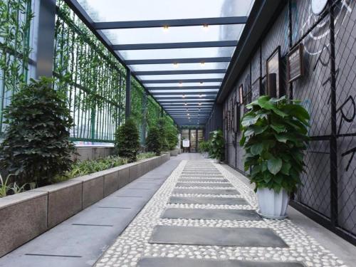 a walkway in a building with a ceiling and a plant at James Joyce Coffetel·Chengdu Chunxi in Chengdu