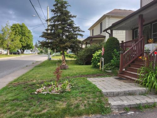 a house with a tree on the side of the street at 75 inch high mud house with separate entrance and exit, one bedroom, one living room, private bathroom, there is a cute cat, a few minutes walk to many restaurants, 8 minutes drive to the big waterfall in Niagara Falls