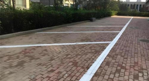 a brick parking lot with white lines on it at Magnotel Harbin Songbei Wanda Wenlvcheng in Harbin