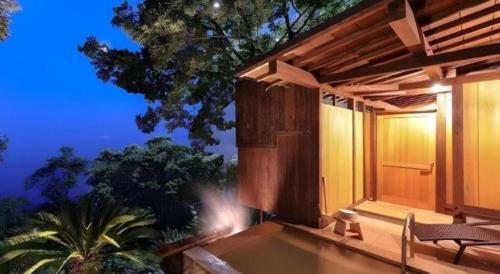 a porch of a house with a table and a chair at HOTEL FUTARI KOMOREBI in Atami