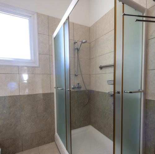 a shower with a glass door in a bathroom at Penthouse, City Center, Walking to Beach in Larnaka