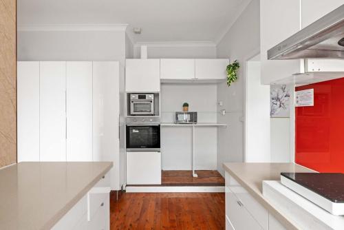a kitchen with white cabinets and a red refrigerator at Spacious Double Ensuite Room in Marsfield - Well-Connected Suburb in Epping