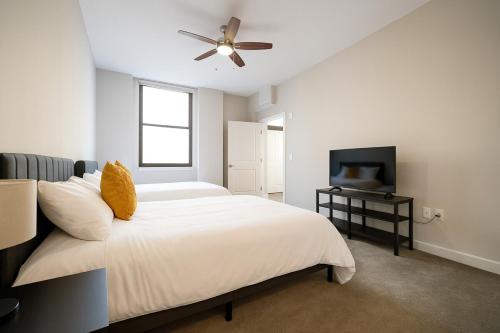 a bedroom with a bed with a ceiling fan and a television at Spacious Downtown Sq Stadium, Casino, R&R HoF! in Cleveland