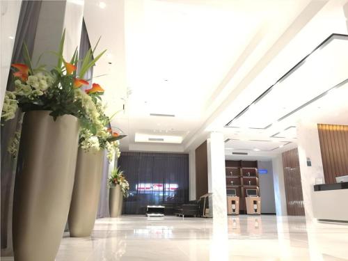 a lobby with large vases with flowers in it at City Comfort Inn Shenzhen Shiyan Science and Technology Park in Shenzhen