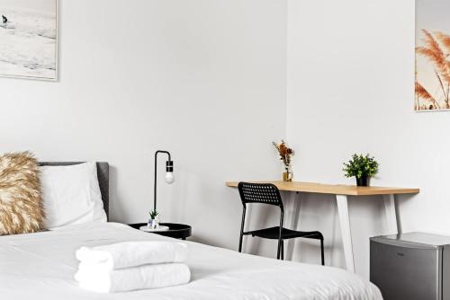 a bedroom with a bed and a table and a desk at Spacious Double Ensuite Room in Marsfield - Well-Connected Suburb in Epping