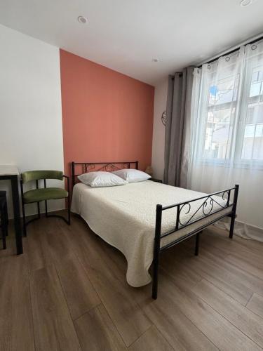 a bedroom with a bed and a chair and a window at Ciel de Cannes in Cannes