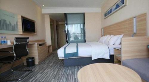 a hotel room with a bed and a desk at City Comfort Inn Lichuan Railway Station Tenglong Cave in Enshi