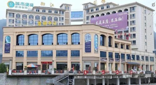 a large building in front of some buildings at City Comfort Inn Lichuan Railway Station Tenglong Cave in Enshi