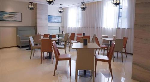 a restaurant with tables and chairs in a room at City Comfort Inn Hainan Tunchang Changsheng Road 