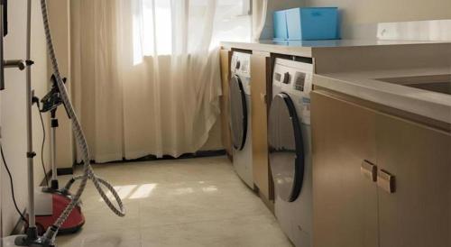 a laundry room with a washing machine and a sink at City Comfort Inn Hainan Tunchang Changsheng Road 