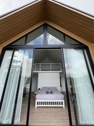 a bedroom in the roof of a house with windows at River Hill Khaokho in Khao Kho